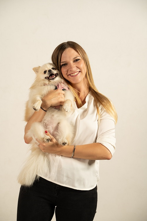 La blogueuse "Jenny" avec la chienne Spitz nain "Nala". La photo montre notre blogueuse Jenny, qui tient dans ses bras sa chienne blanche Nala, un spitz nain. Toutes deux "sourient" à la caméra".